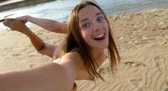 Junge Nudistin beim FKK nackt am See