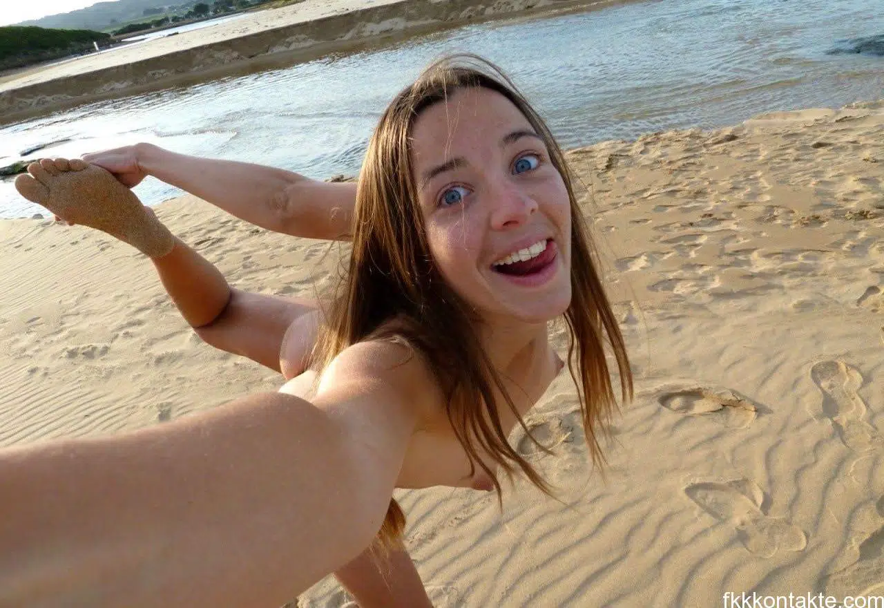 Junge Nudistin beim FKK nackt am See