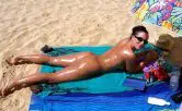 Nudistin beim Nacktsonnen im FKK-Urlaub