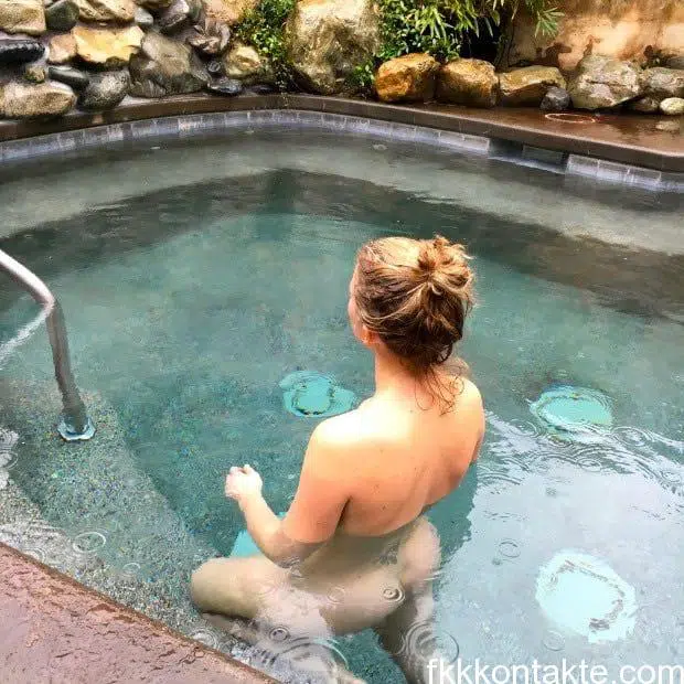 Nacktes FKK Girl beim Baden im Pool
